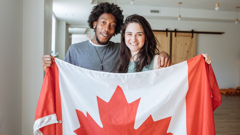 Duas pessoas com uma bandeira do Canadá