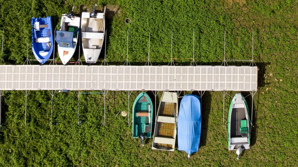 Barcos em lama seca no lago francês-suíço de Brenets