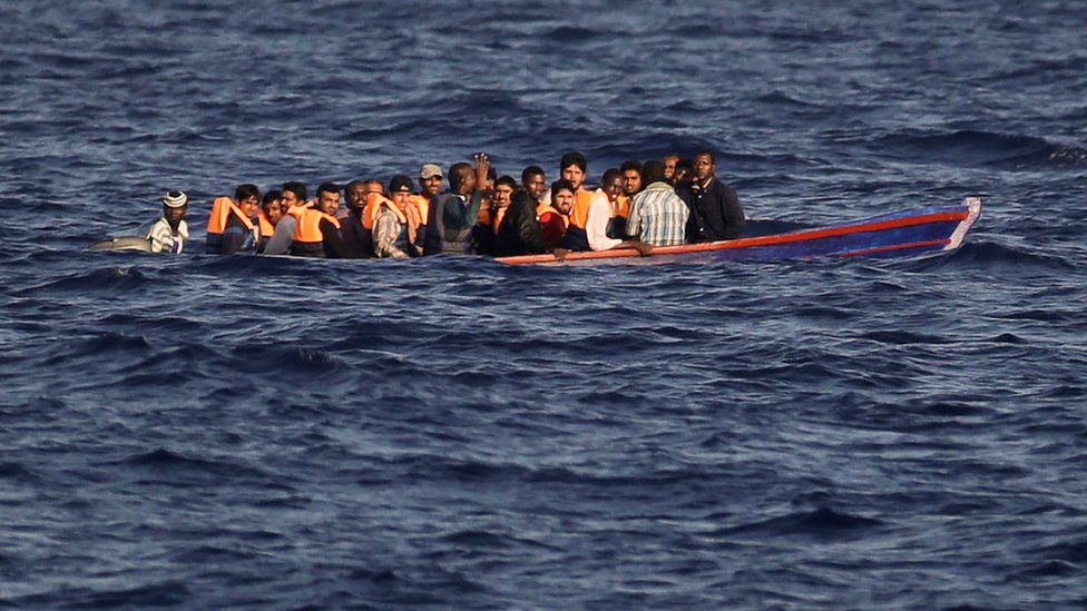 Мигранты и беженцы, покидающие Ливию на борту деревянной лодки в Средиземном море 28 августа 2016 г.