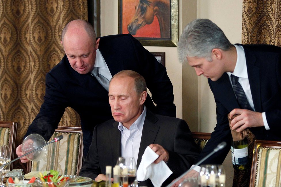 2011年11月的照片顯示，普裏戈津（左）在莫斯科附近的一個宴會上協助普京