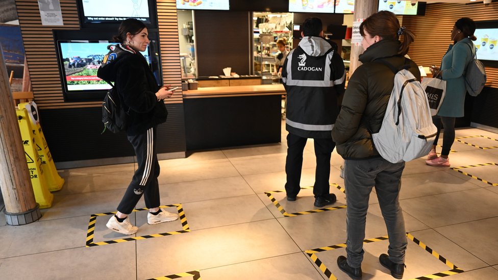 Лента отмечает пол, на котором клиенты должны стоять, чтобы практиковать социальное дистанцирование, чтобы снизить риск распространения коронавируса в ресторане McDonald's в Лондоне, Великобритания