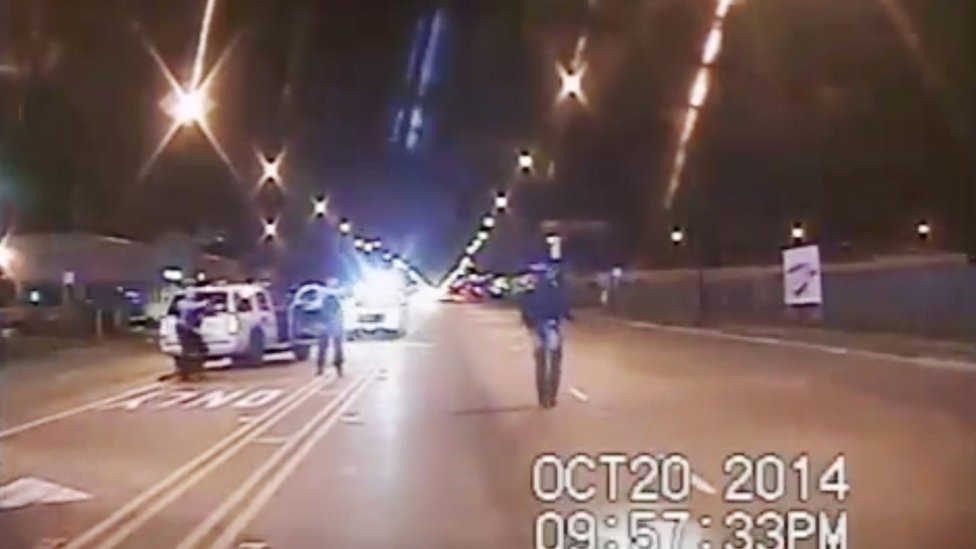 На этом кадре из видео с видеорегистратора, предоставленного полицейским управлением Чикаго, Лакуан Макдональд (справа), выпущенный 20 октября 2014 года, идет по улице за несколько минут до того, как его шестнадцать раз застрелил офицер полиции Джейсон Ван Дайк в Чикаго.