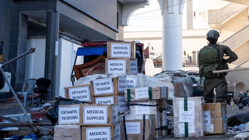 Izraelski vojnik sa paketima medicinske pomoći ispred Al Šife