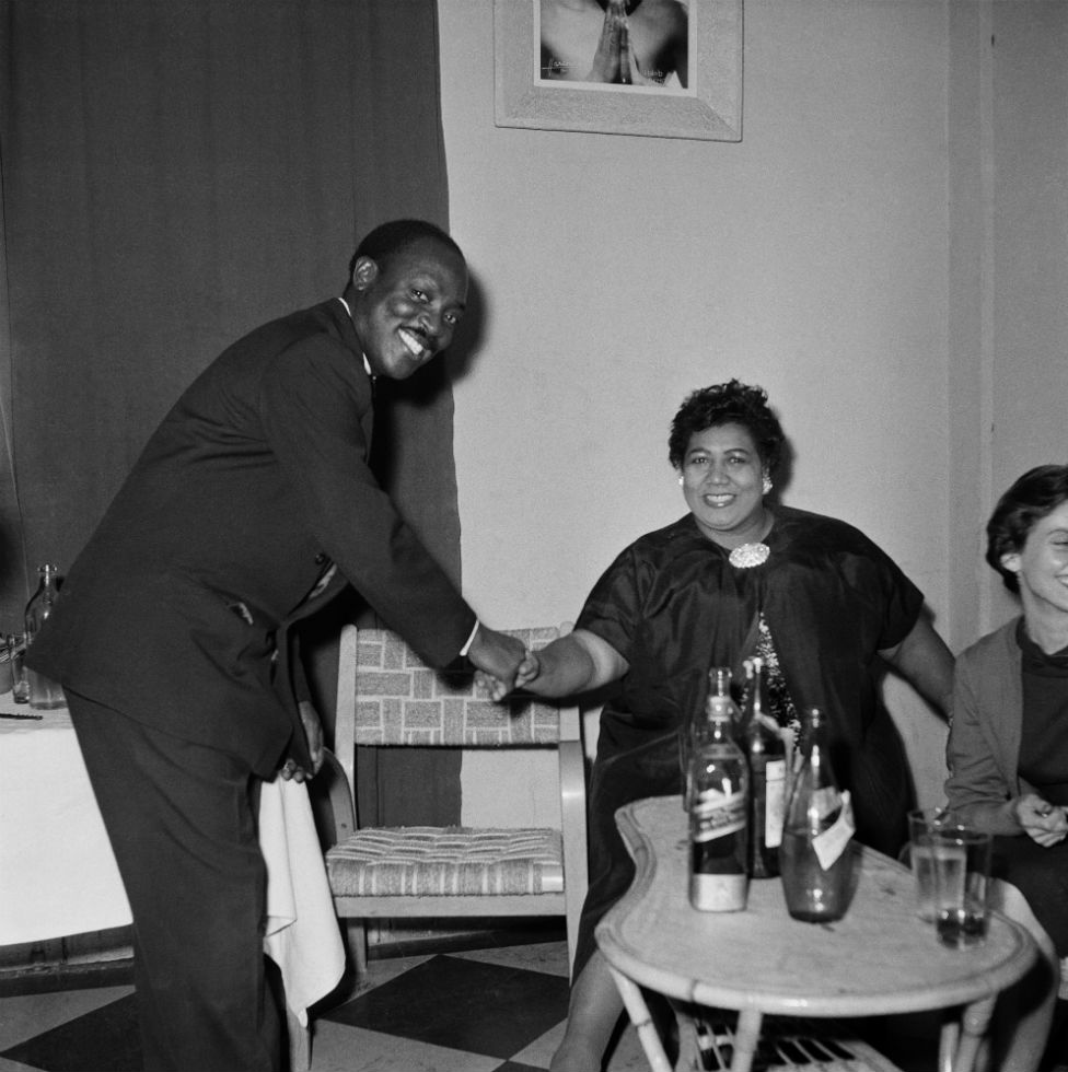 Roger DaSilva shakes hands with US jazz singer Velma Middleton in a self-timed photograph.