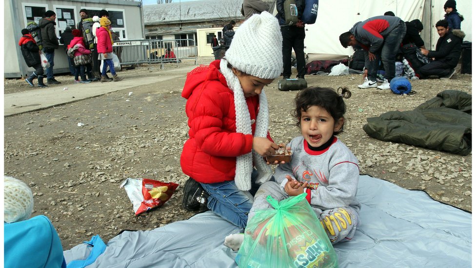 طفلتان سوريتان أمام معبر لاجئين في اليونان