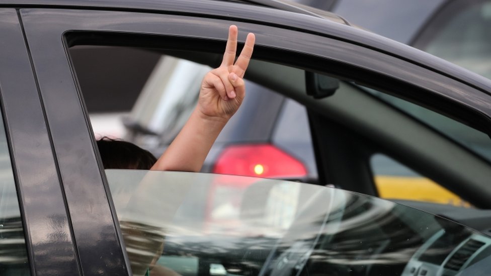 Протестующий показывает знак победы из автомобиля во время митинга в Минске, Беларусь