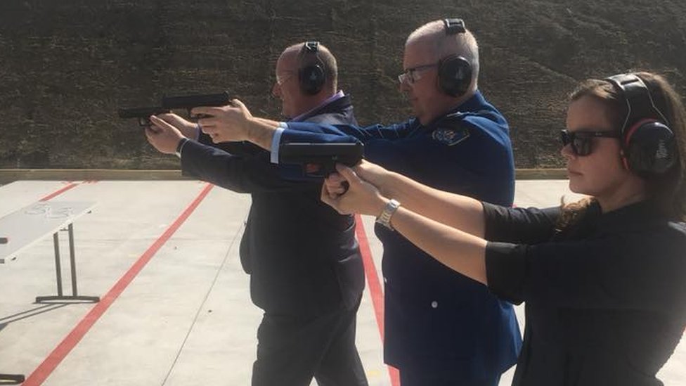 Дэвид Эллиот и другие стреляют из пистолетов по целям на открытии стрельбища в Сиднее