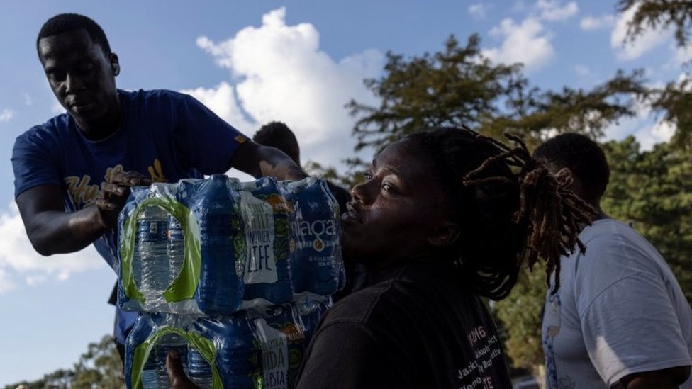 Voluntários ajudam na entrega de água