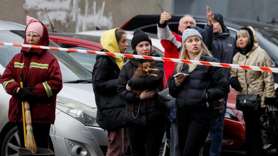 People react at the site of a Russian missile strike in Kyiv