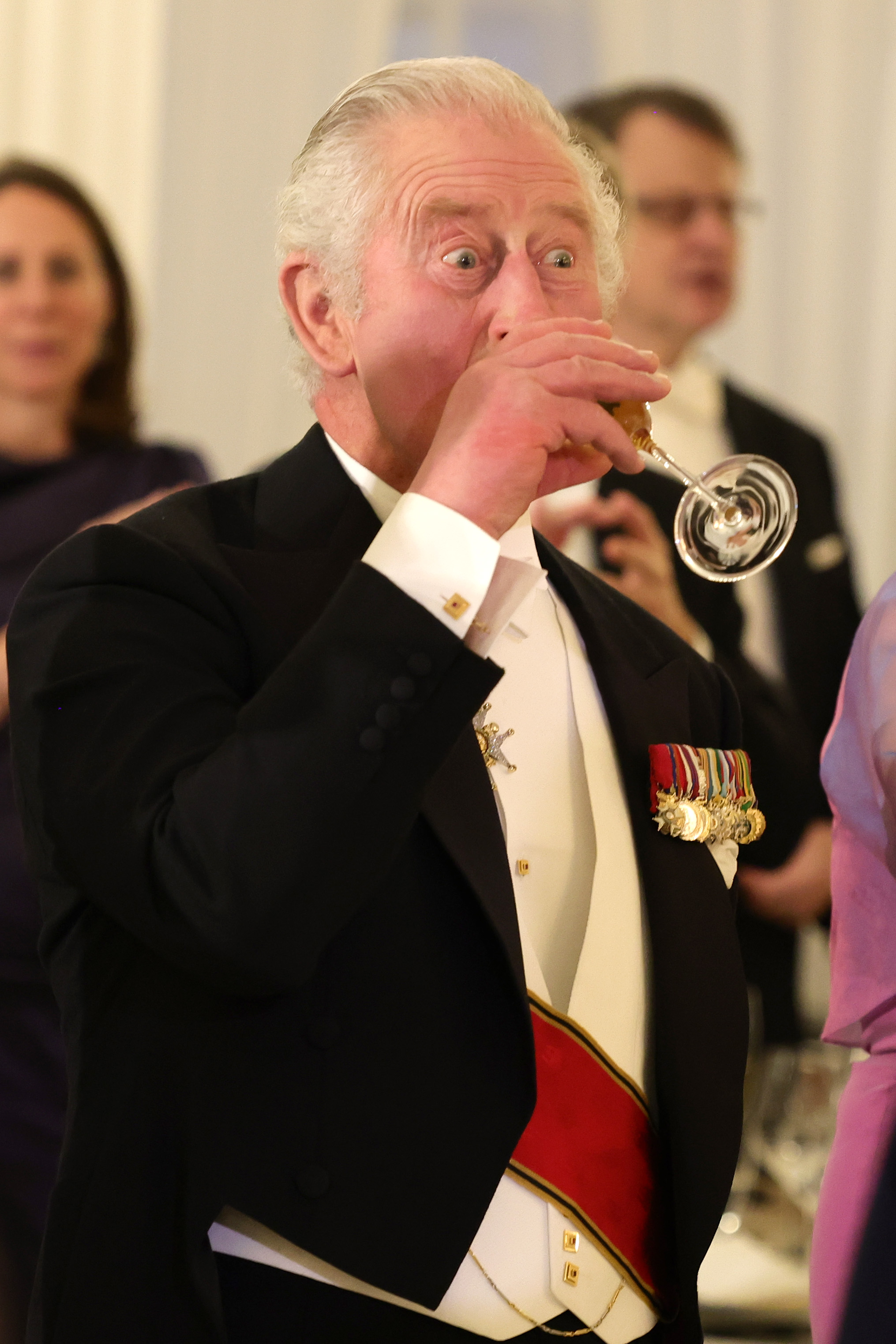 King Charles drinks from a Champagne flute during a state banquet at the Bellevue Palace