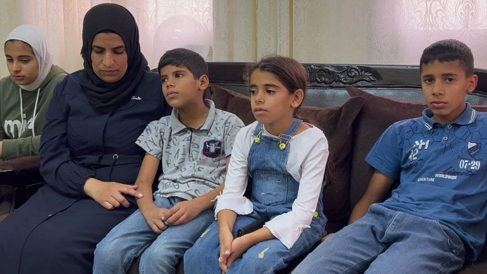 Ihlas Saleh sa četvoro dece starosti od devet do 14 godina sedi na krevetu