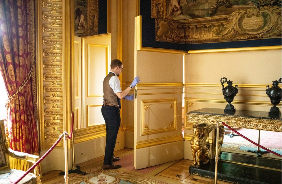 Fjodor walks through a doorway in a state apartment