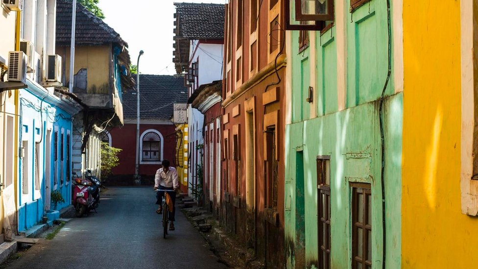 Los portugueses inspiraron cocinas de todo el mundo, incluidas la India -en especial la de Goa- y la de Malasia. Un hombre en una bicicleta por una colorida calle de Goa