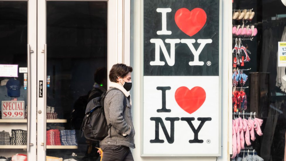 Un hombre pasa por delante de un letrero que dice: Yo amo Nueva York.
