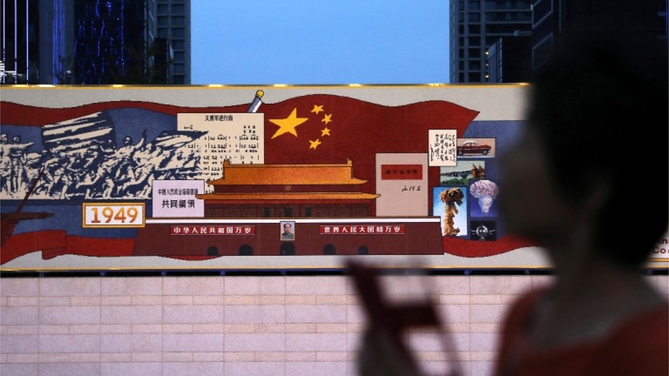 6月23日，一名市民經過北京的中共成立100週年慶祝圖像。