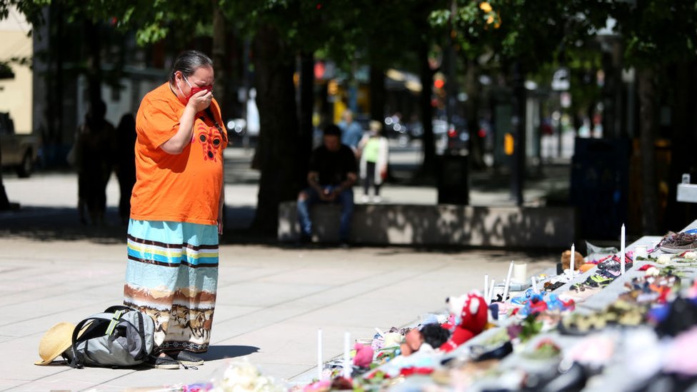 Una mujer llora frente a una vigilia en Canadá