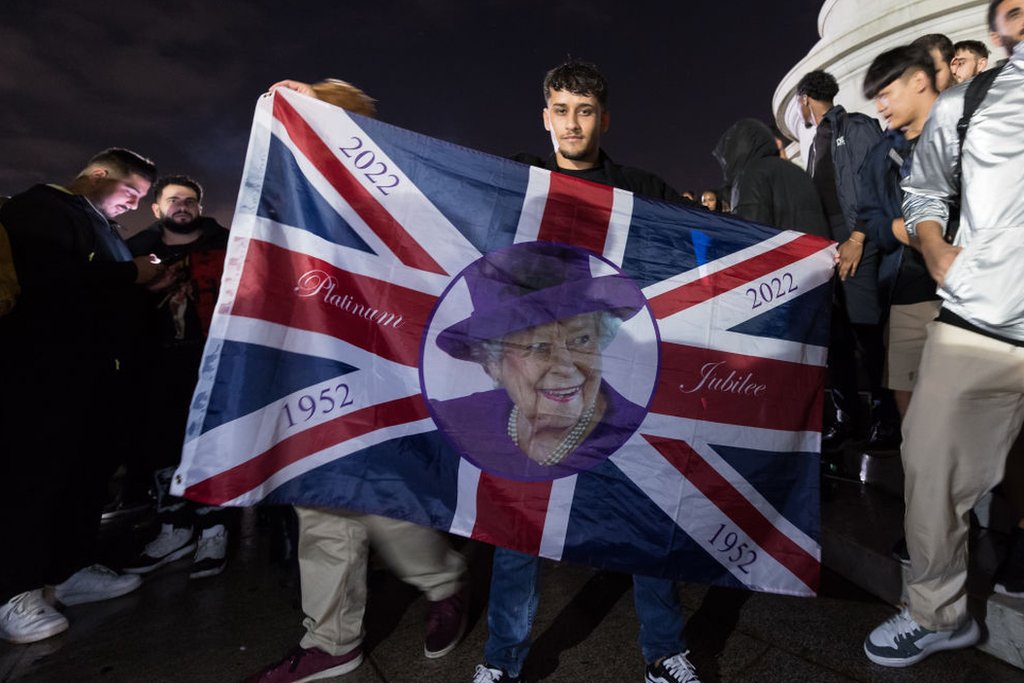 Homem com bandeira com rosto de Elizabeth 2ª