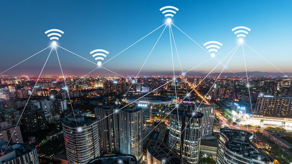 El teléfono consume mucha energía para intentar conectarse a una red saturada o con una señal baja. Paisaje nocturno ciudad con señales de wifi.