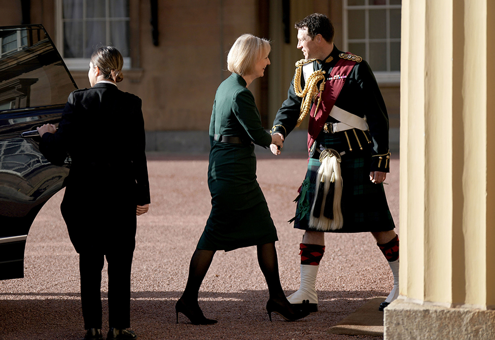 رئيسة الوزراء المستقيلة ليز تراس تُستقبل من قبل مساعد الملك تشارلز الثالث، المقدم جوني تومبسون، لدى وصولها إلى قصر باكنغهام في 25 أكتوبر/ تشرين الأول 2022