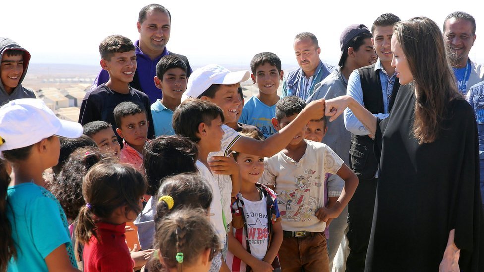 Американская актриса и посол доброй воли ООН Анджелина Джоли ткнулась кулаками с сирийским мальчиком во время своего визита в лагерь сирийских беженцев Азрак в 90 км к востоку от Аммана, Иордания