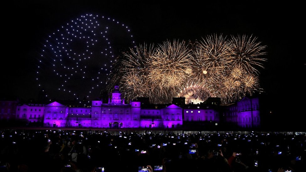 People record a drone depiction of Britain's late Queen Elizabeth during the New Year's celebrations, in central London, Britain, January