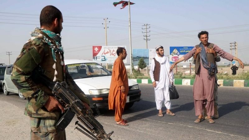 جنود أفغان يفتشون رجلا عند نقطة تفتيش في ولاية هرات