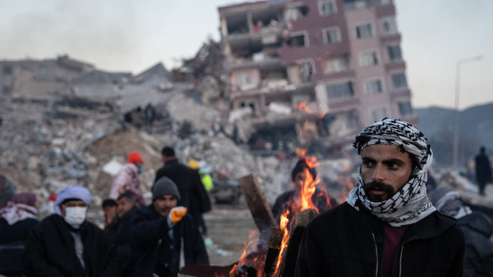 Warga menunggu kabar dari keluarganya yang diperkirakan masih terperangkap di bawah reruntuhan di Hatay, Turki.