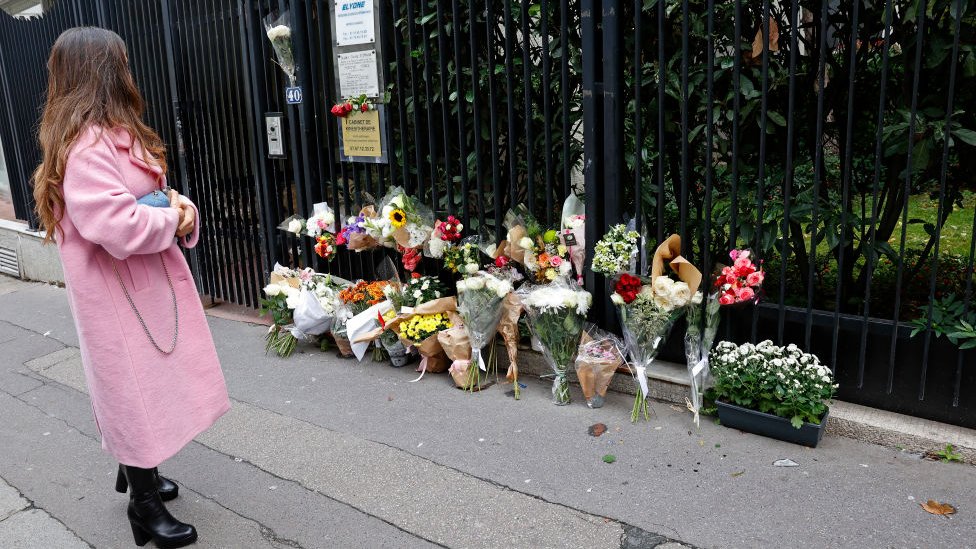 Ubistvo devojčice u Parizu: Tinejdžerka pronađena mrtva u kutiji, vezanih ruku i nogu 2 A woman looks at flowers displayed outside the building where a 12-year-old schoolgirl Lola lived and who was murdered on October 18, 2022 in Paris, France