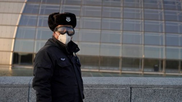 رجل صيني يلبس قناعاً واقياً من عدوى فيروس كورونا