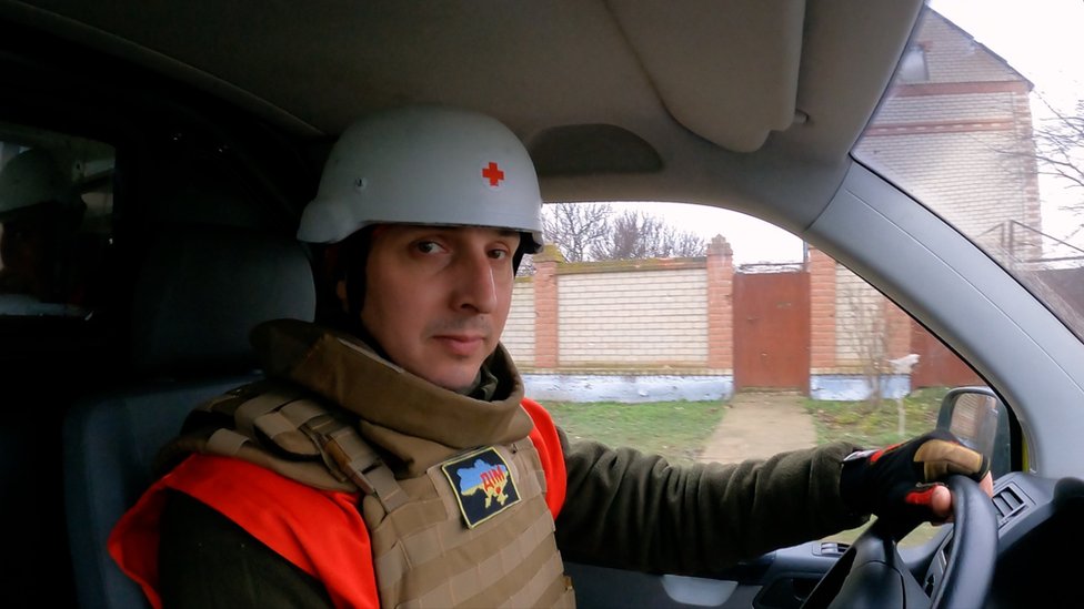 Dmitro, voluntario de Cruz Roja, sentado en su carro.