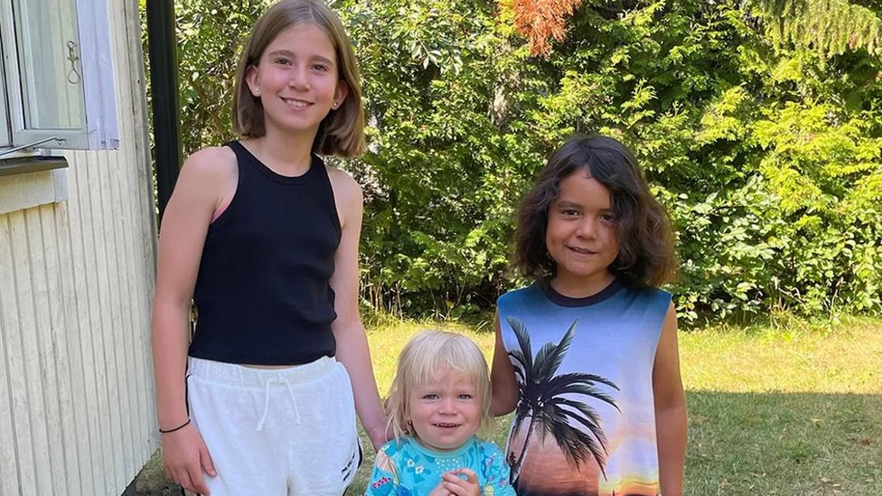 Fotografia colorida mostra duas criancas branca e uma crianca negra