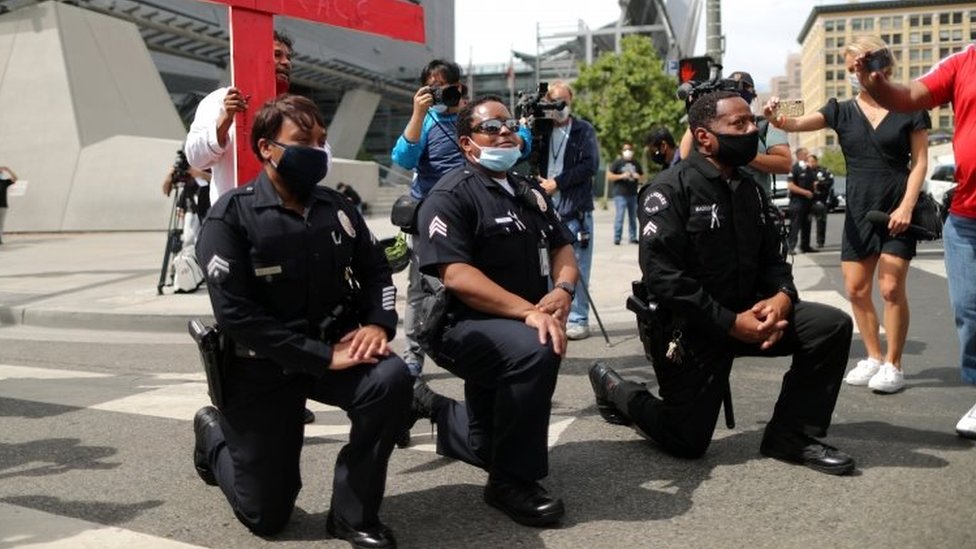 Policías arrodillados en una protesta