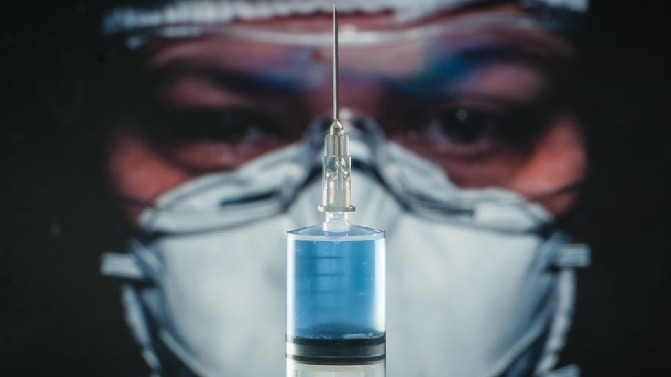 Pessoa com vacina em frente ao rosto