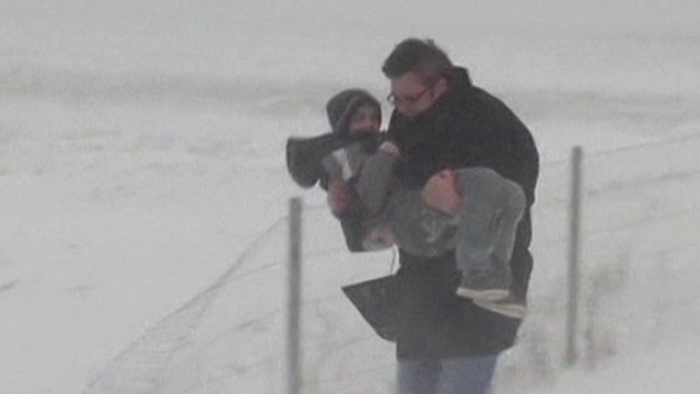 Man carrying child in snow