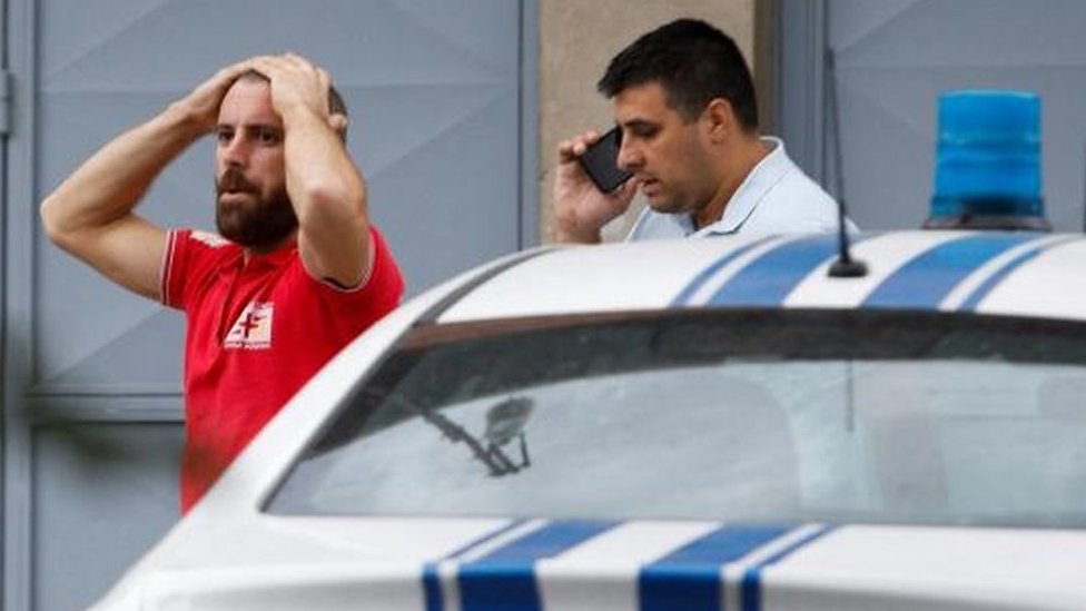 A medical worker reacts at a crime scene of a mass shooting in which 12 people, including the gunman, were killed, according to local media reports, in Cetinje, Montenegro August 12