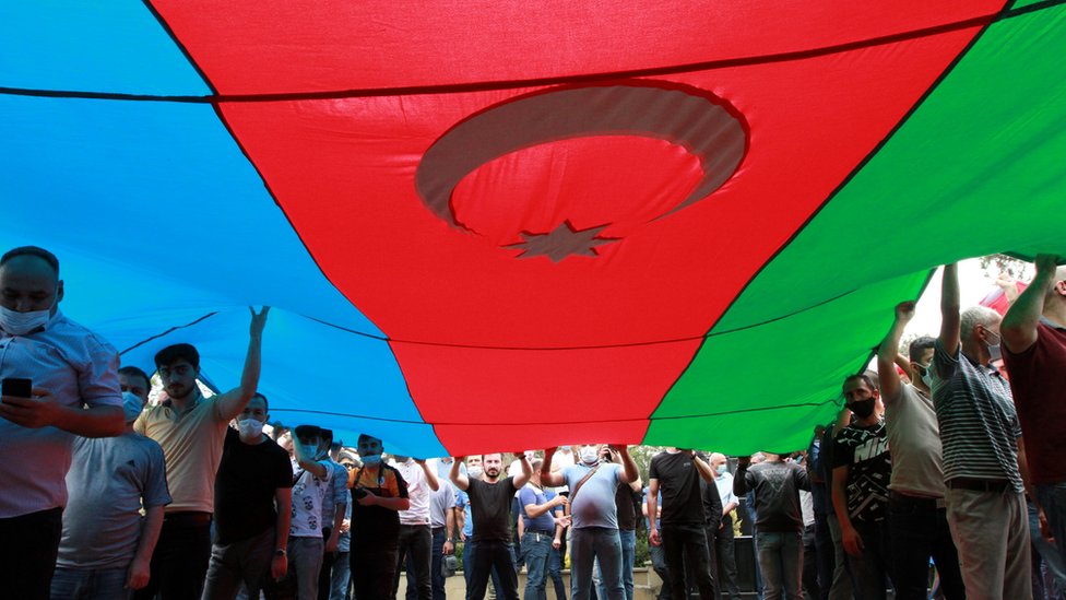 أشخاص يحملون علما ضخما لأذربيجان