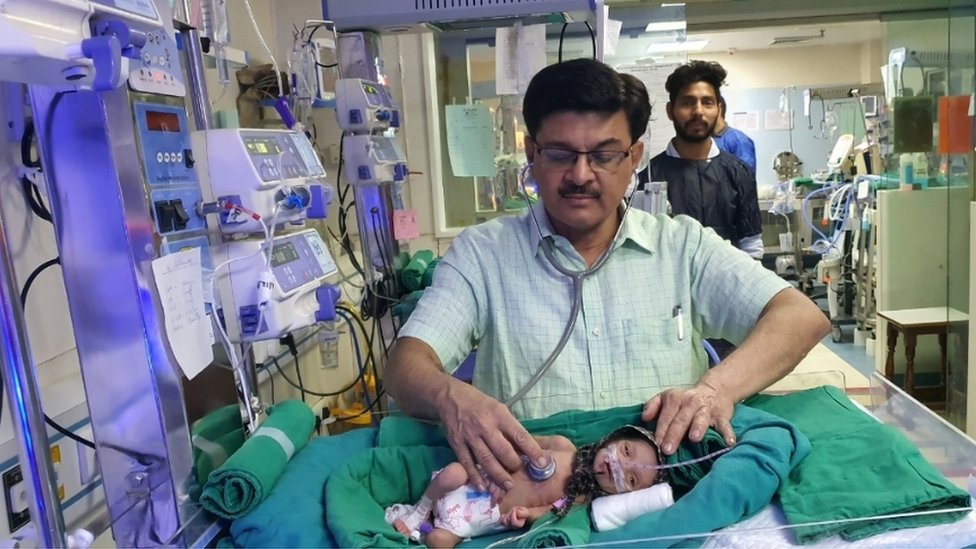 Dr Ravi Khanna con la bebé en el hospital.