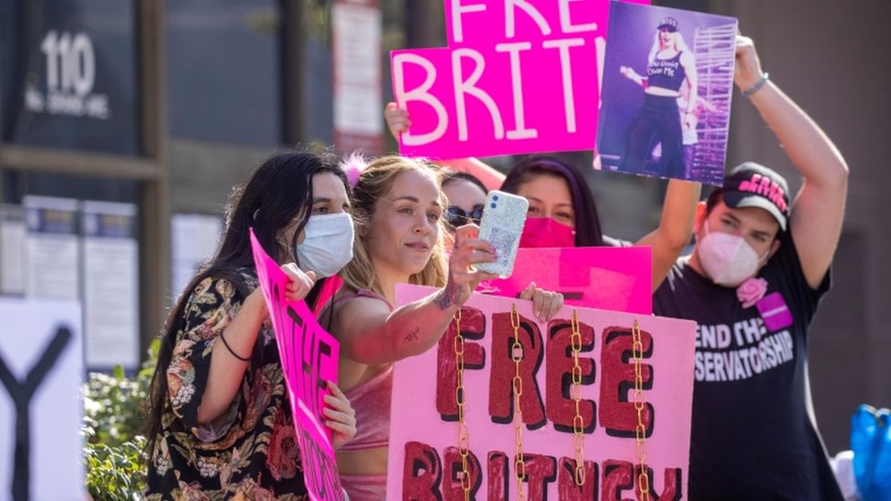 Seguidores de Britney Spears afuera de una corte con carteles que dicen "Liberen a Britney".