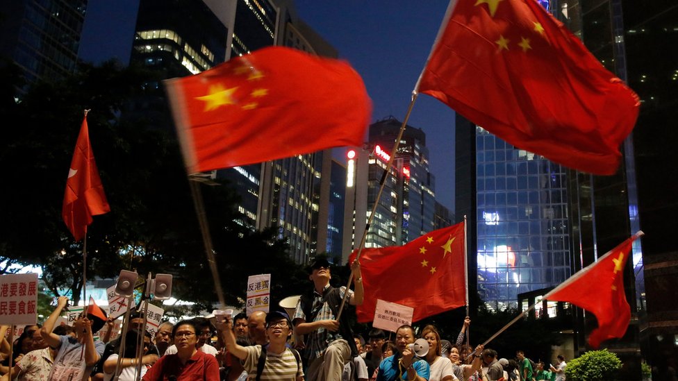 Пропекинские протестующие машут китайскими флагами в Гонконге