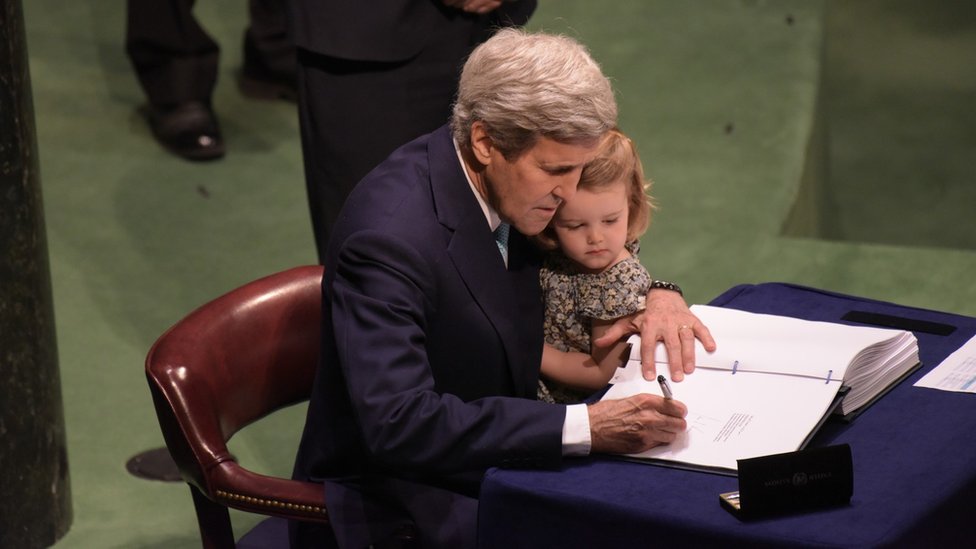 John Kerry firmando el acuerdo de París sobre cambio climático con su nieta en 2016.