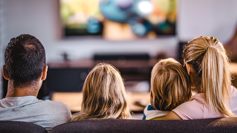 Семья вместе смотрит телевизор