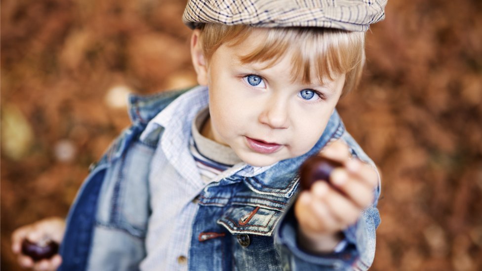 En Reino Unido, los niños juegan con las castañas, atravesándoles una pita y, por turnos, golpeando la del otro jugador hasta que alguna se rompa. Niño con castaña de indias