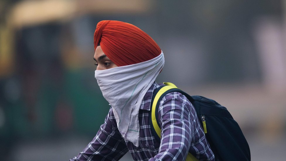hombre en moto con rostro tapado por la contaminación hombre en moto con rostro tapado por la contaminación