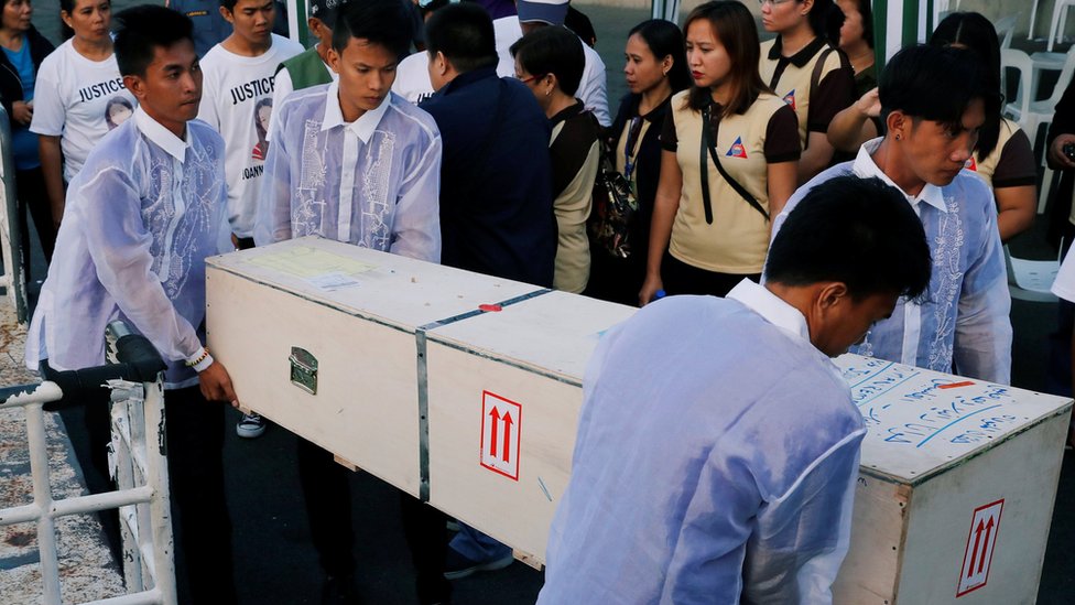Похоронные работники несут ящик с телом Джоанны Демафелис ??в ее родном городе в провинции Илоило на Филиппинах 17 февраля 2018 года.