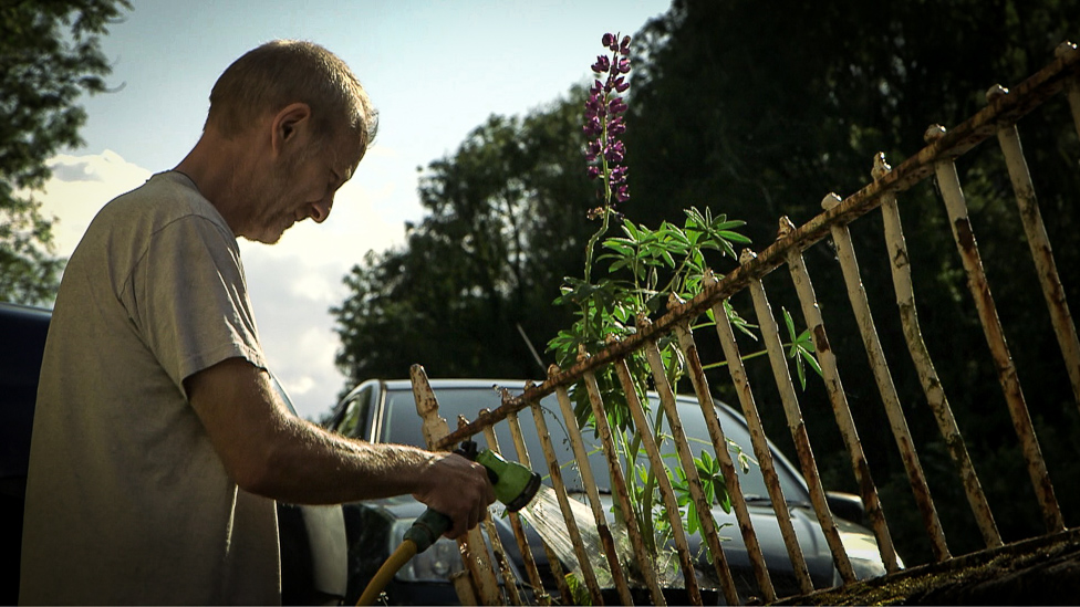 Житель Исталифера Крис Джонс поливает свой сад