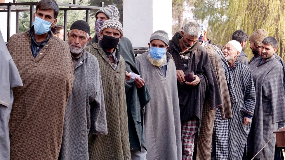 Voters wait in a queue during polling in Shopian.