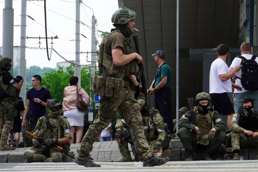 Members of Wagner group sit on the sidewalk as they patrol the centre of Rostov-on-Don, on 24 June 2023