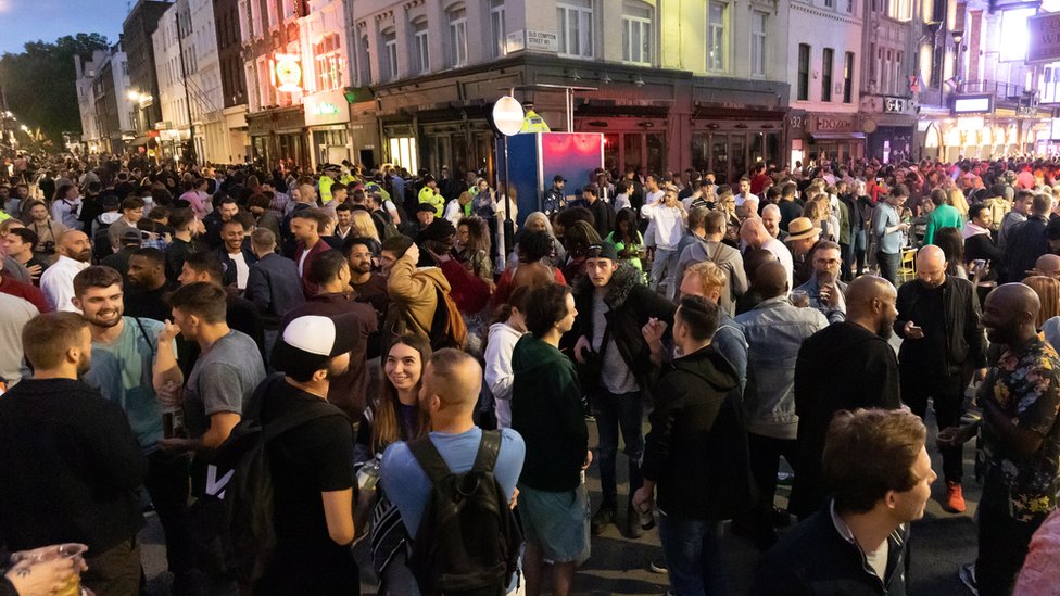 Revellers drink and socialise in the street in Soho, London