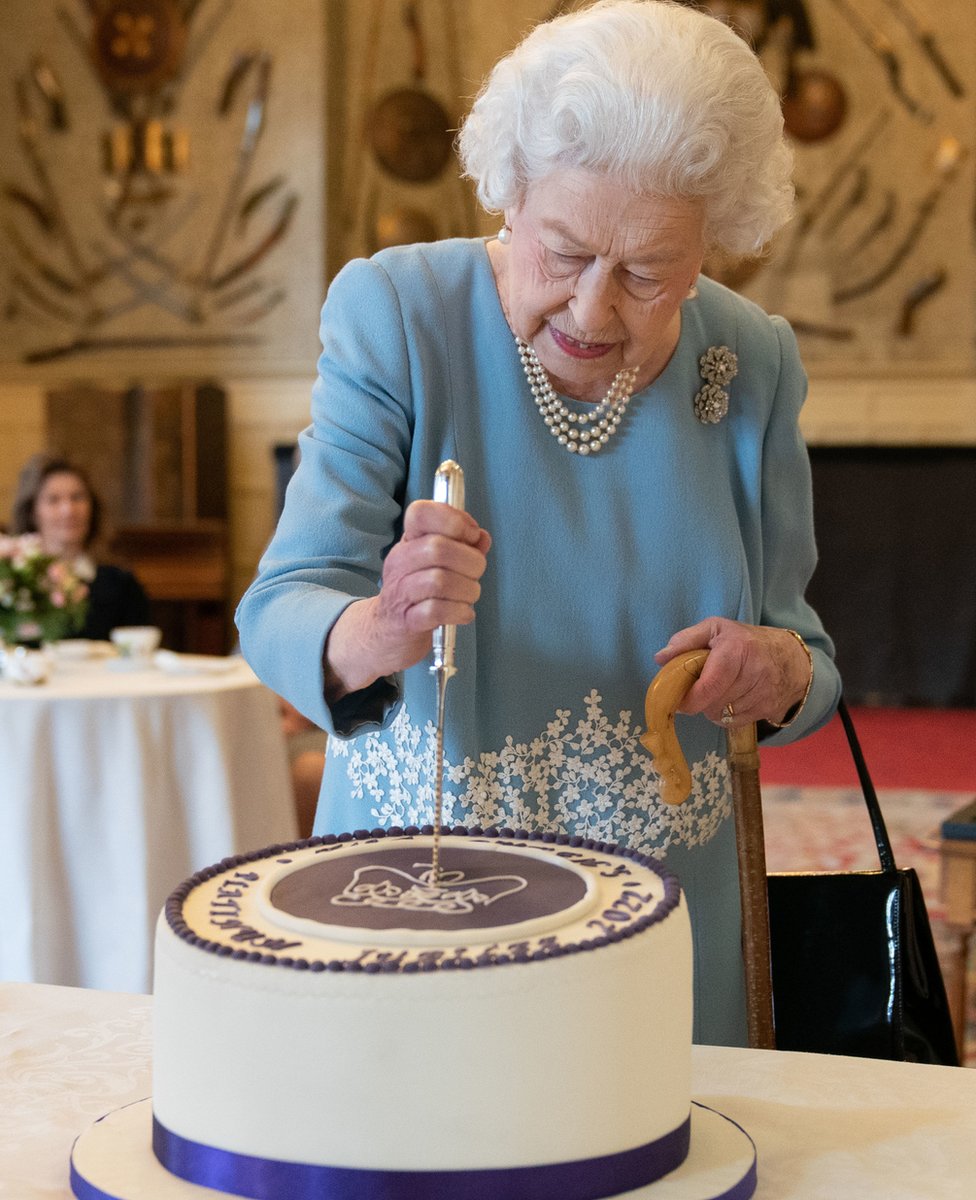 Queen Elizabeth II cutting a cake