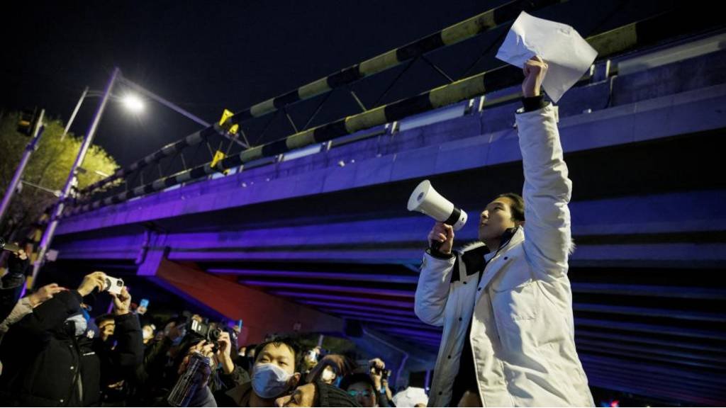 11月28日，在北京，在為烏魯木齊火災受害者守夜後，一名男子拿著白紙抗議當局的疫情封控措施。